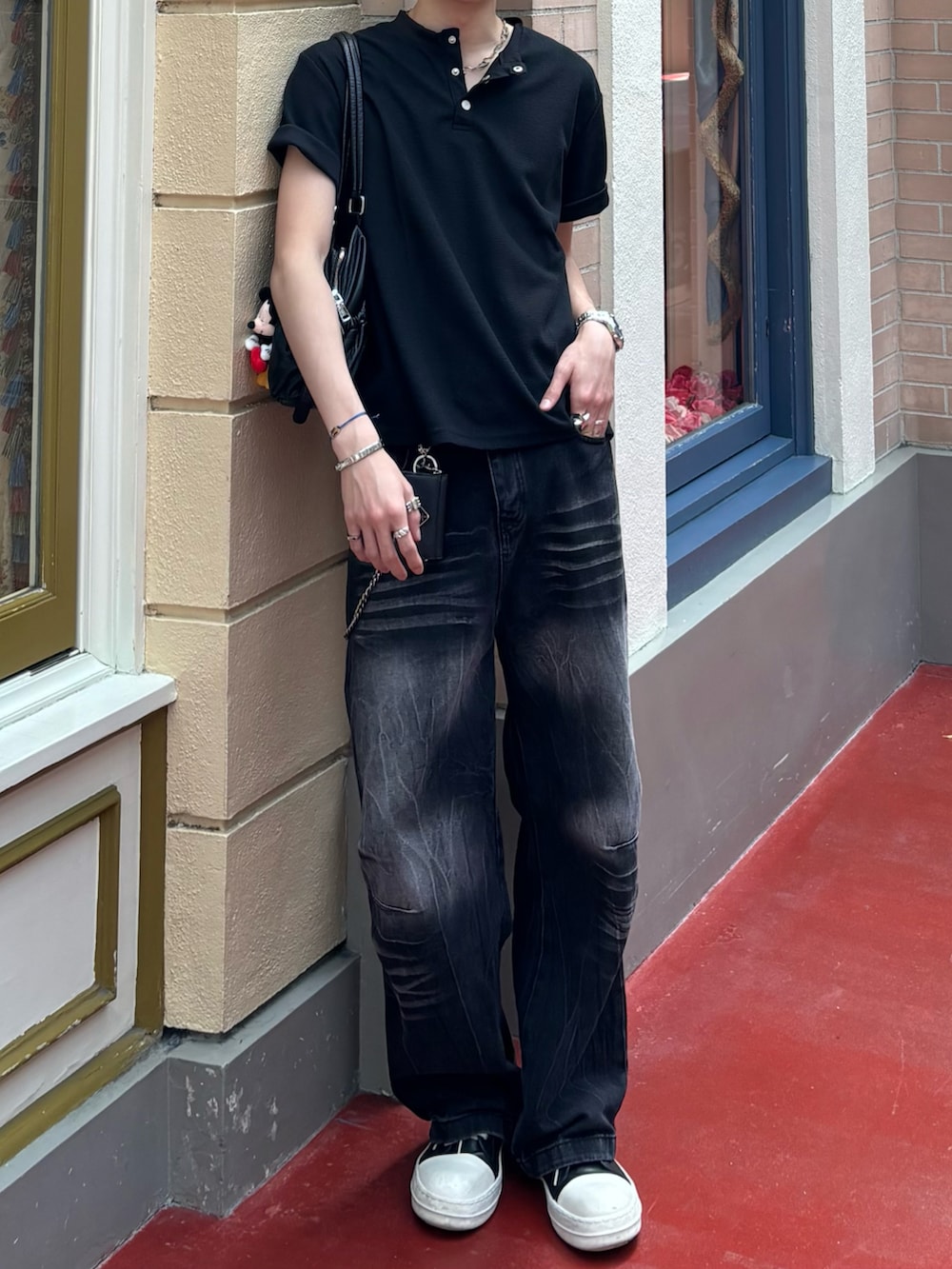 ブラック系のTシャツ/カットソー、ブラック系のデニムパンツ、ブラック系のスニーカーを着用したメンズの春コーディネートの2枚目の写真