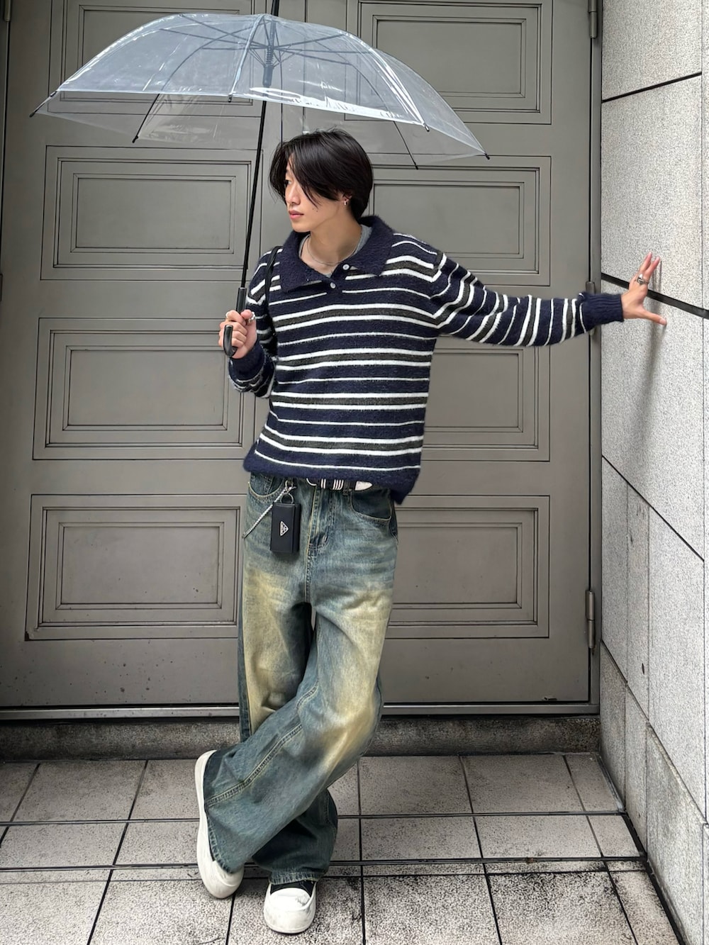 ブルー系のニット/セーター、ブルー系のデニムパンツ、ブラック系のスニーカーを着用したメンズの秋コーディネートの2枚目の写真