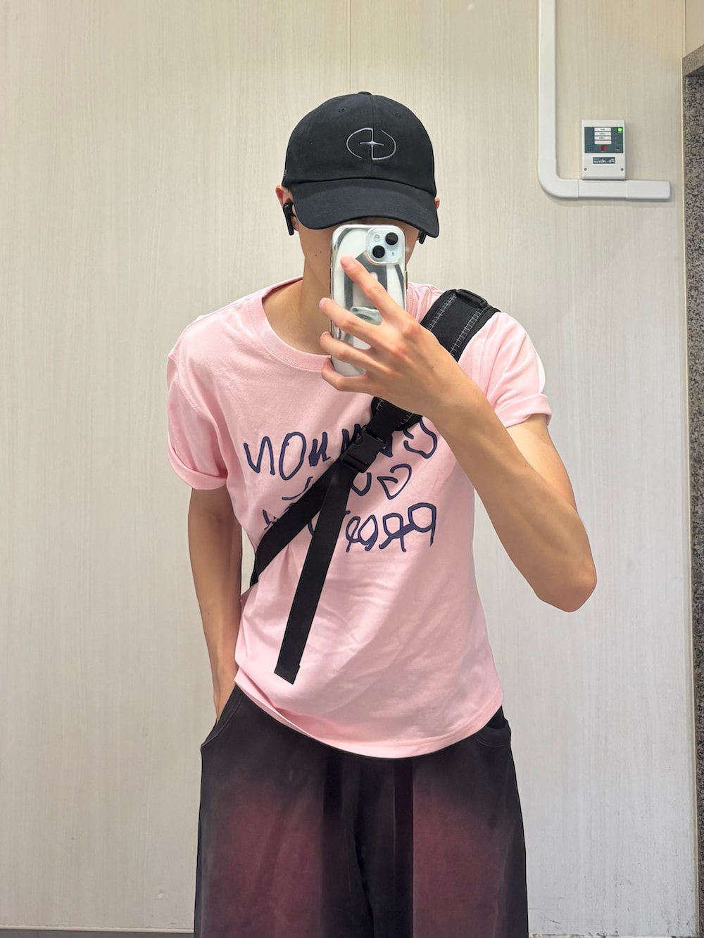 ピンク系のTシャツ/カットソー、ブラック系のスウェットパンツ、ブラック系のサンダルを着用したメンズの夏コーディネートの3枚目の写真