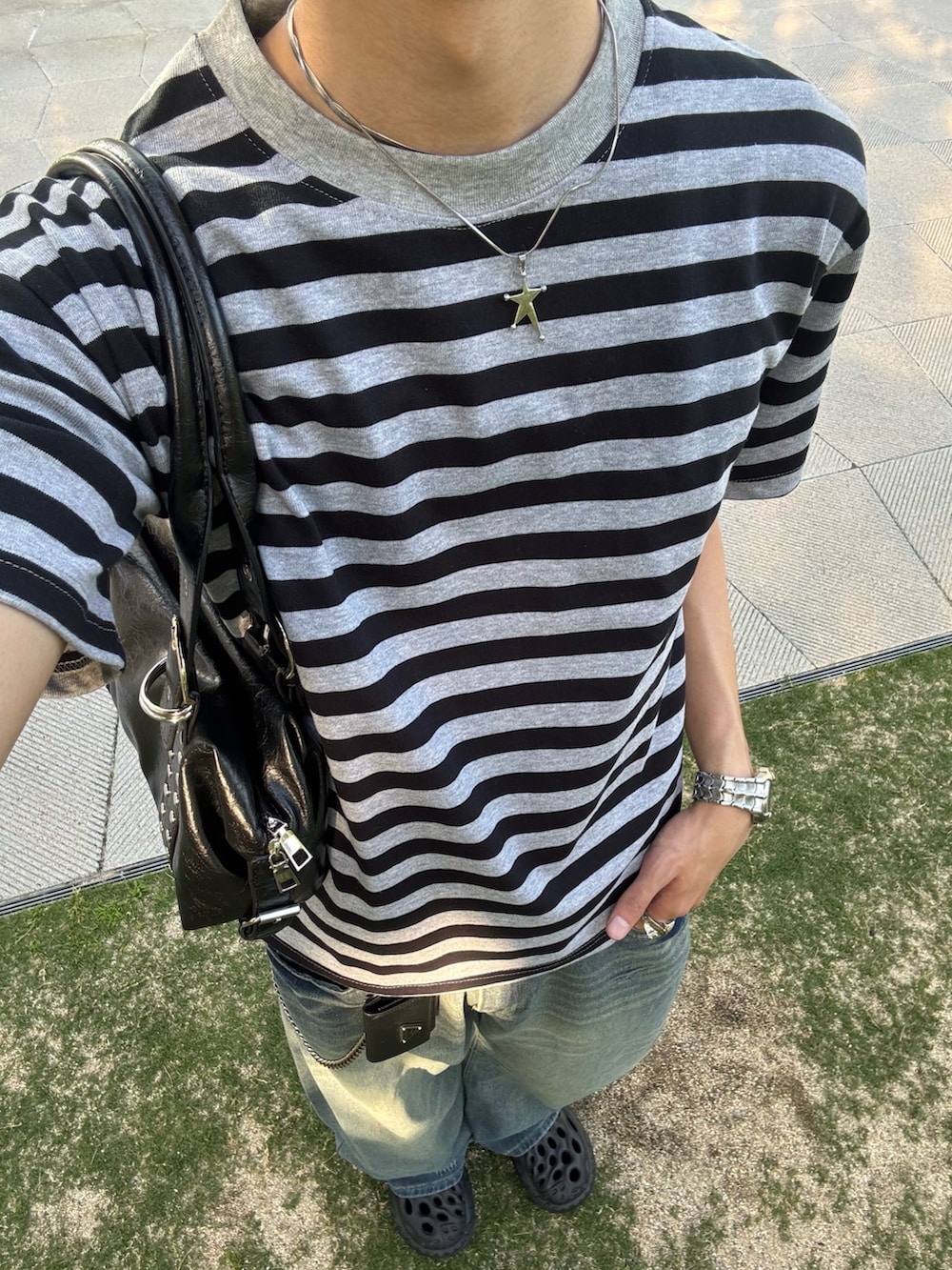 グレー系のTシャツ/カットソー、ブルー系のデニムパンツ、ブラック系のサンダルを着用したメンズの春コーディネートの4枚目の写真