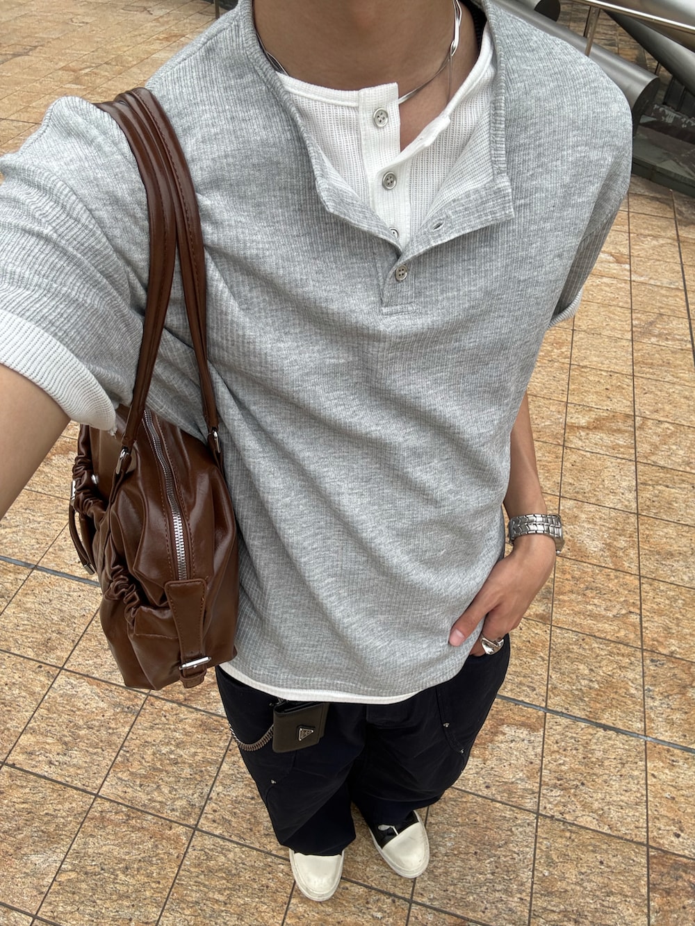 グレー系のTシャツ/カットソー、ブラウン系のショルダーバッグ、ブルー系のチノパンツを着用したメンズの春コーディネートの4枚目の写真