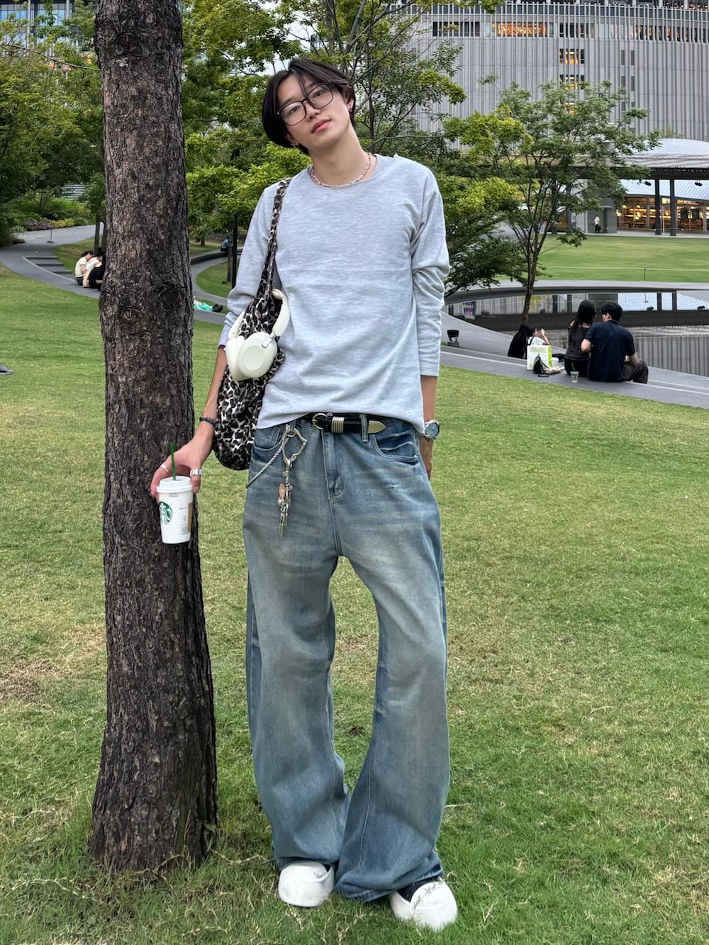 グレー系のTシャツ/カットソー、ブルー系のデニムパンツ、ブラック系のスニーカーを着用したメンズの秋コーディネートの3枚目の写真