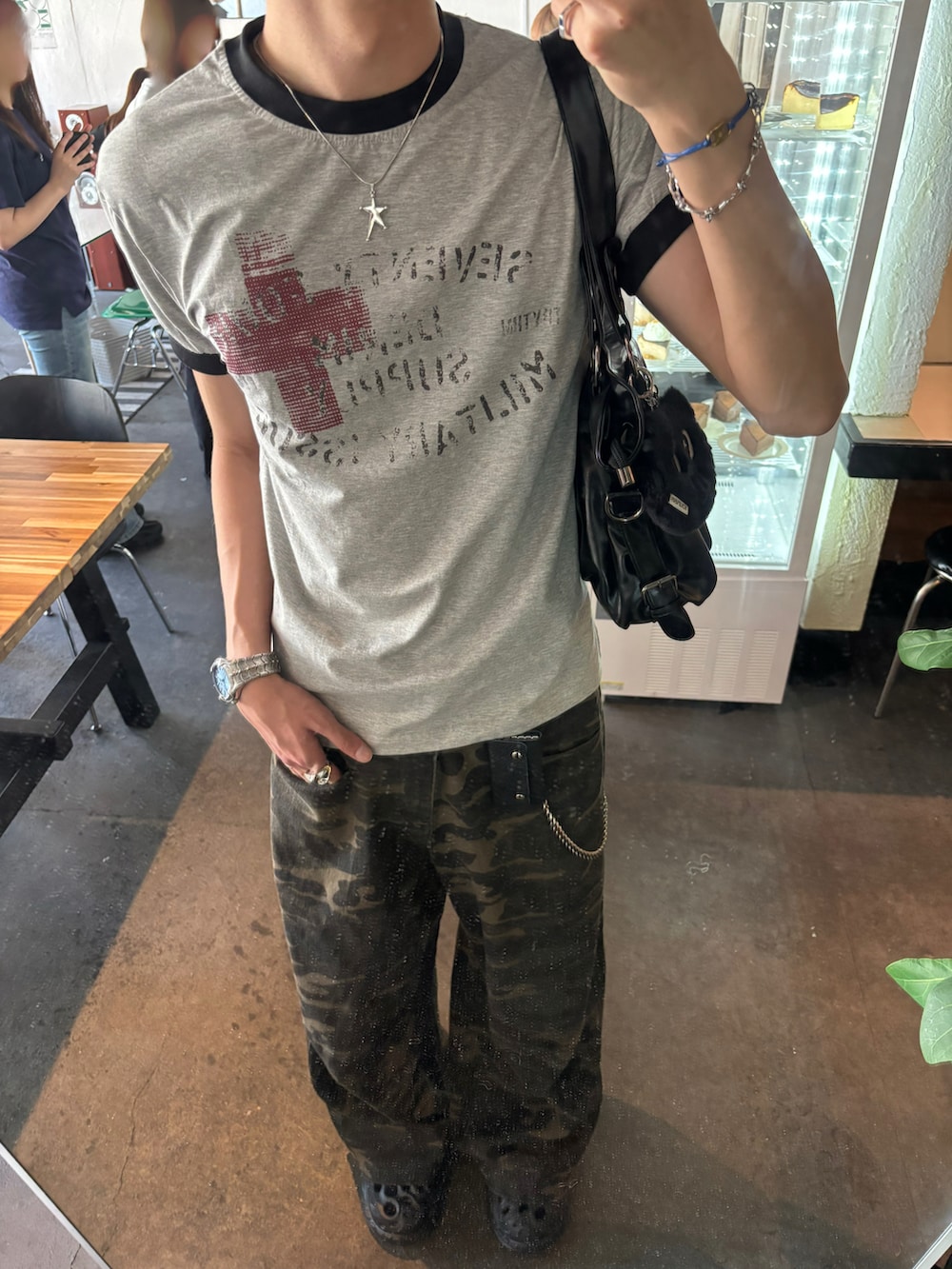 グレー系のTシャツ/カットソー、ブラック系のショルダーバッグ、その他のデニムパンツを着用したメンズの春コーディネートの4枚目の写真