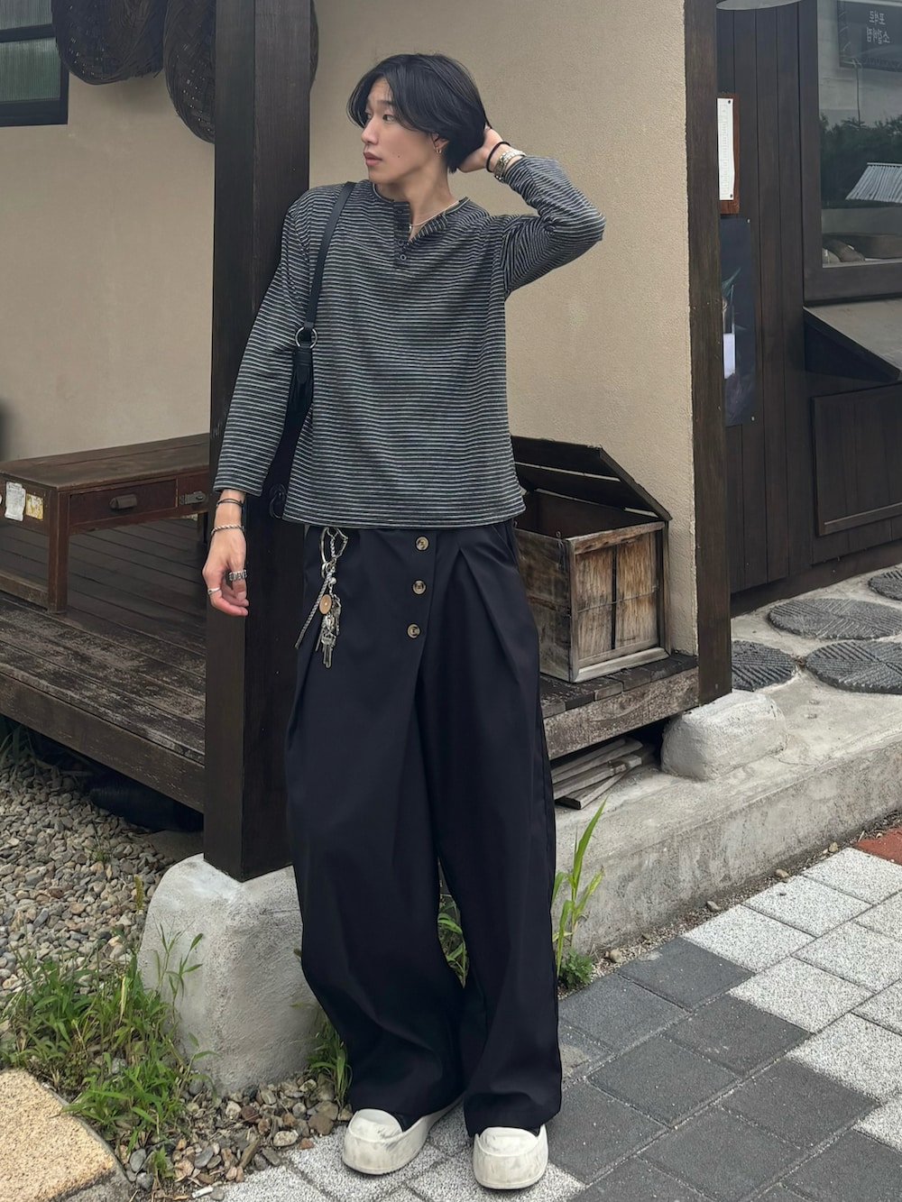 ブラック系のスラックス、ブラック系のスニーカー、グレー系のTシャツ/カットソーを着用したメンズの秋コーディネートの2枚目の写真