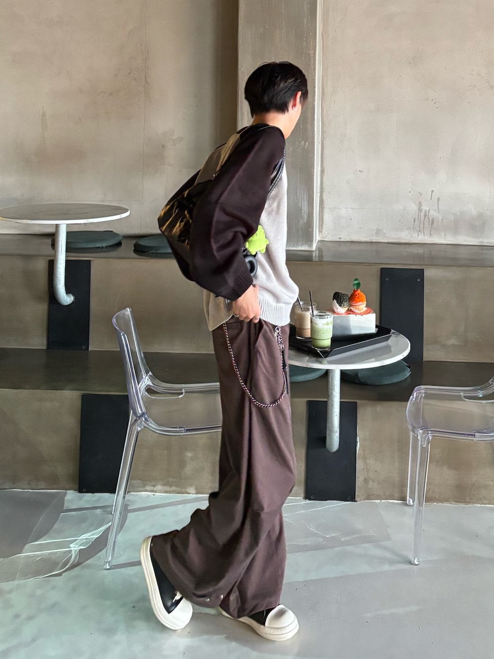 ブラック系のニット/セーター、ブラウン系のスラックス、ブラック系のスニーカーを着用したメンズの秋コーディネートの2枚目の写真