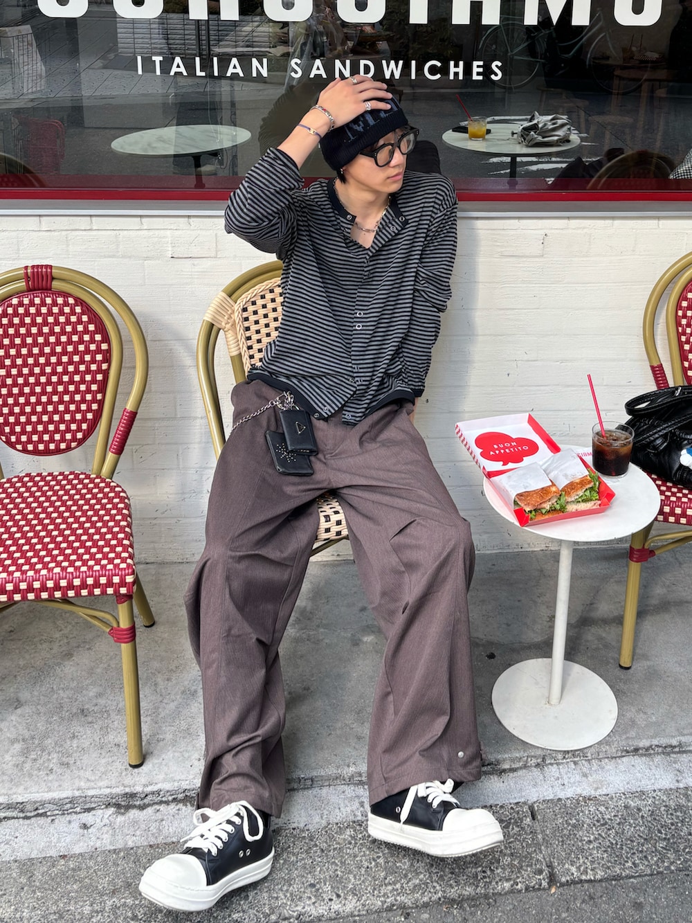 ブラック系のカーディガン/ボレロ、ブラウン系のスラックス、ブラック系のスニーカーを着用したメンズの秋コーディネートの2枚目の写真