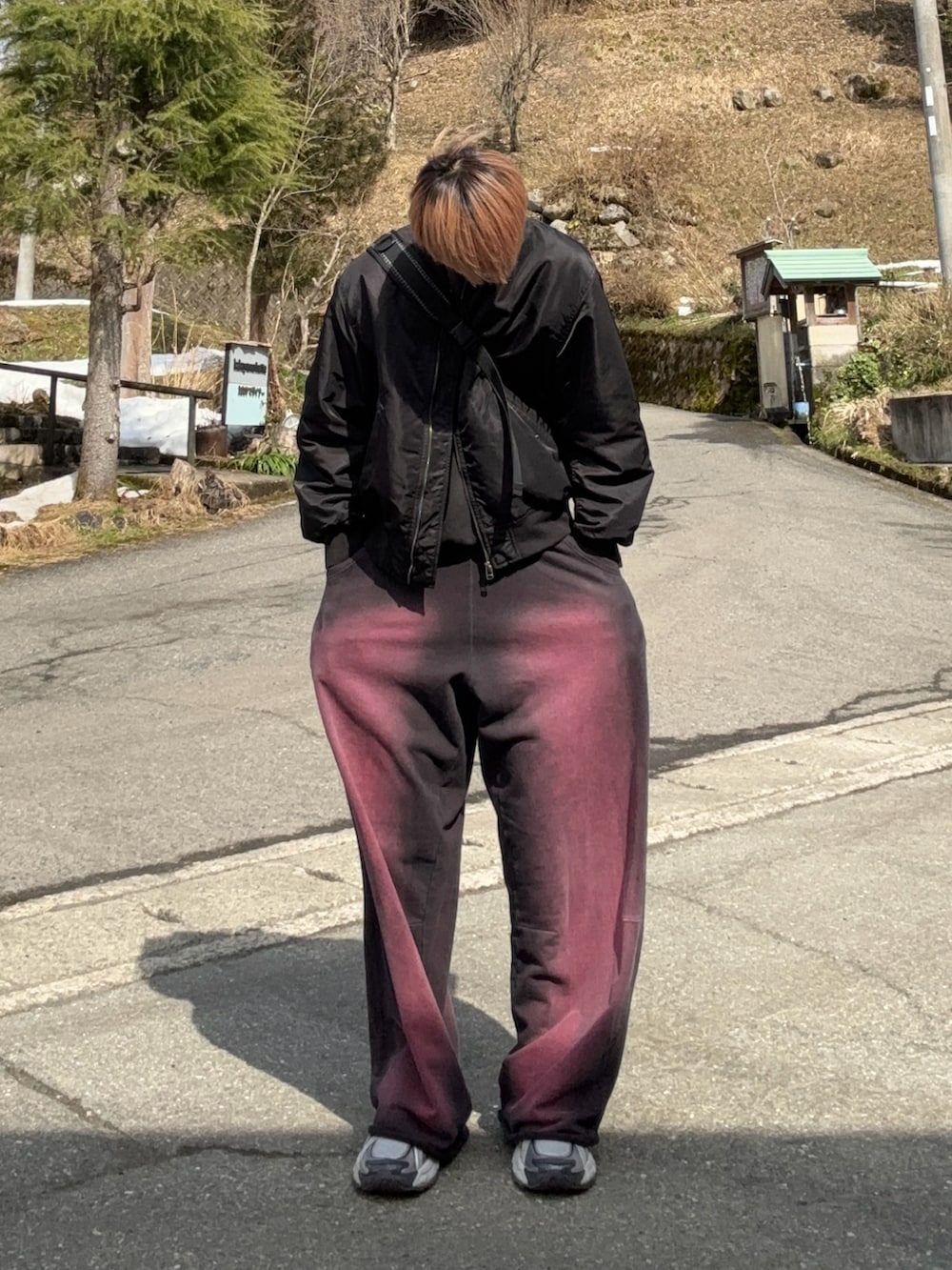 ブラック系のMA-1、レッド系のスウェットパンツ、シルバー系のスニーカーを着用したメンズの春コーディネートの3枚目の写真