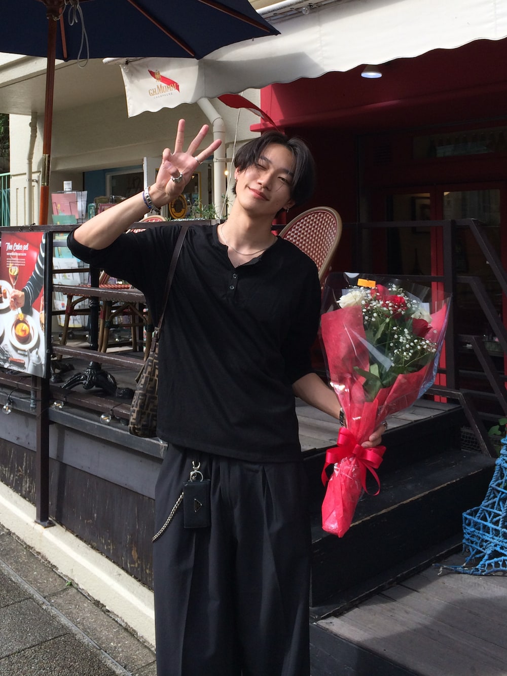 ブラック系のTシャツ/カットソー、ブラック系のスラックス、ブラック系のスニーカーを着用したメンズの夏コーディネートの4枚目の写真