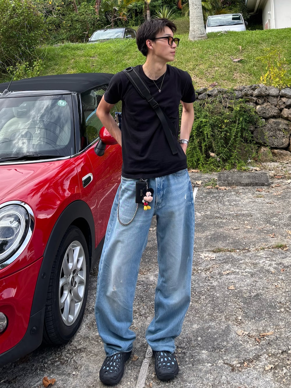 ブラック系のTシャツ/カットソー、ブルー系のデニムパンツ、ブラック系のサンダルを着用したメンズの夏コーディネートの3枚目の写真