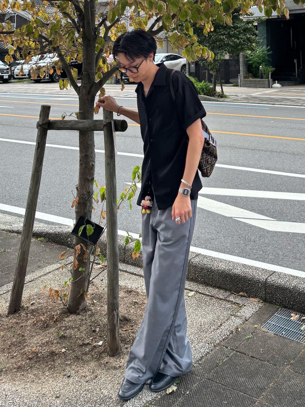 ブラック系のシャツ/ブラウス、グレー系のその他パンツ、ブラック系のローファーを着用したメンズの夏コーディネートの2枚目の写真