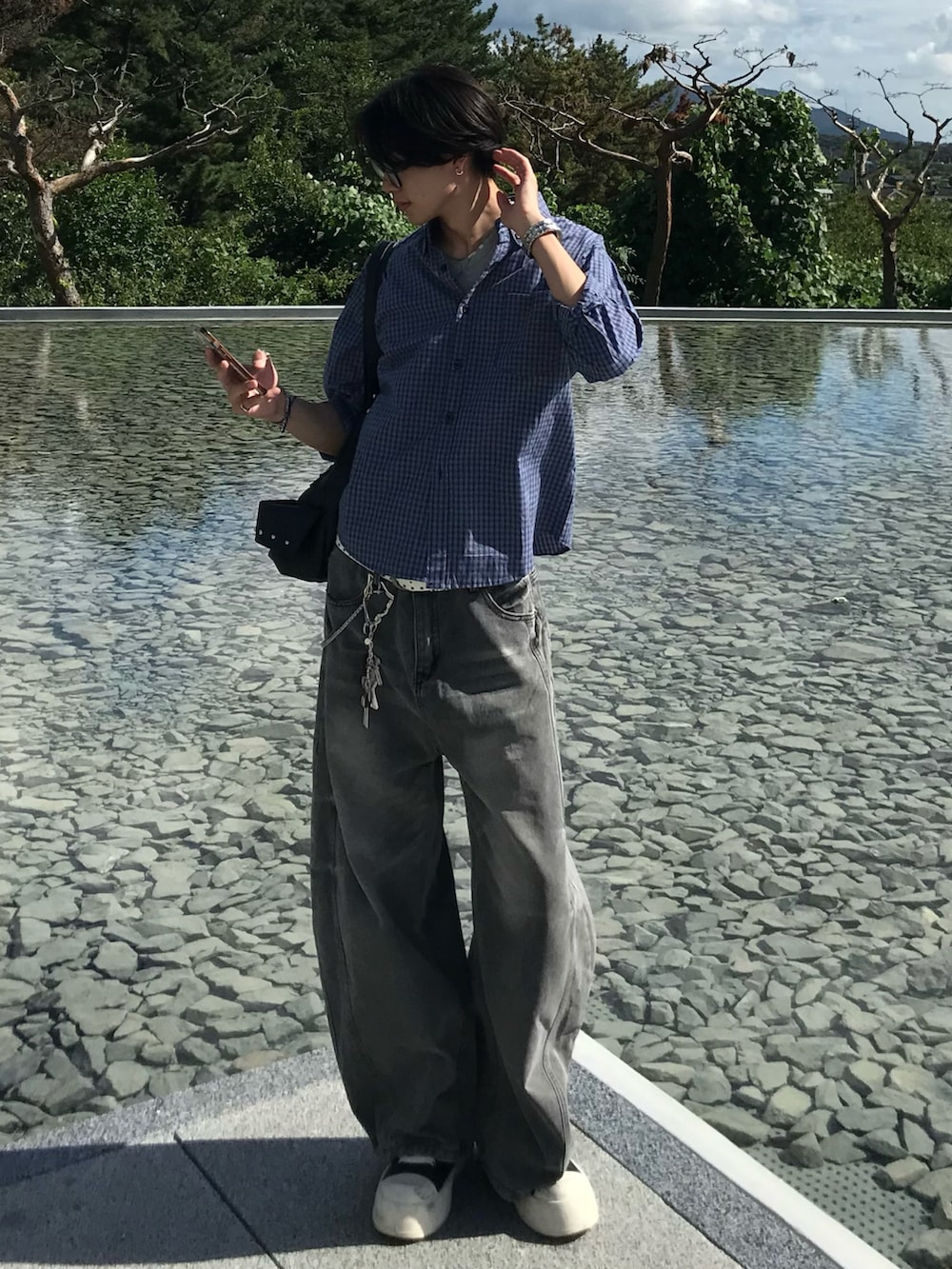 ブルー系のシャツ/ブラウス、グレー系のデニムパンツ、ブラック系のスニーカーを着用したメンズの秋コーディネートの2枚目の写真