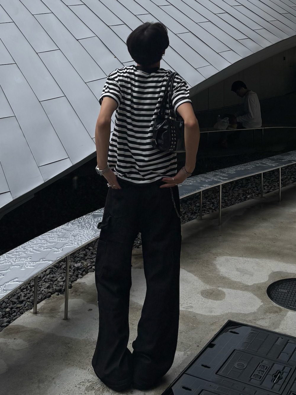 ホワイト系のTシャツ/カットソー、ブラック系のデニムパンツ、ブラック系のショルダーバッグを着用したメンズの春コーディネートの2枚目の写真