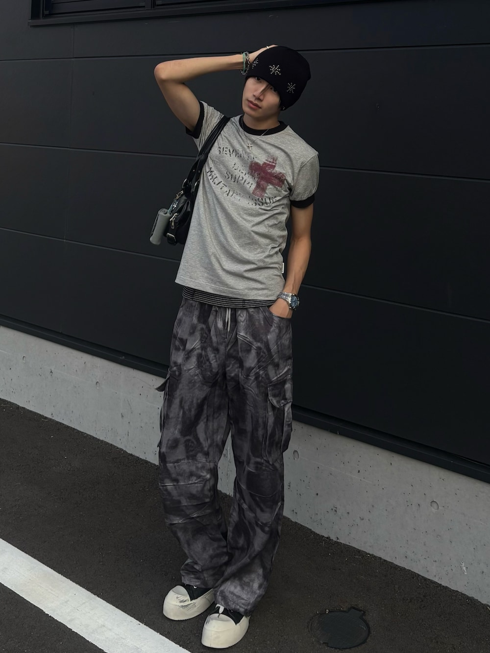 グレー系のTシャツ/カットソー、グレー系のカーゴパンツ、ブラック系のスニーカーを着用したメンズの夏コーディネートの3枚目の写真