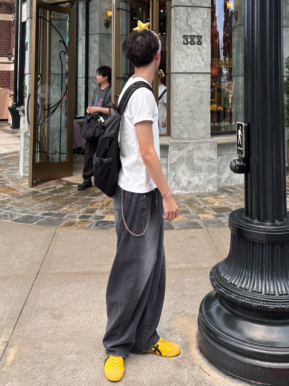 ホワイト系のTシャツ/カットソー、ブラック系のデニムパンツ、イエロー系のスニーカーを着用したメンズの夏コーディネートの2枚目の写真