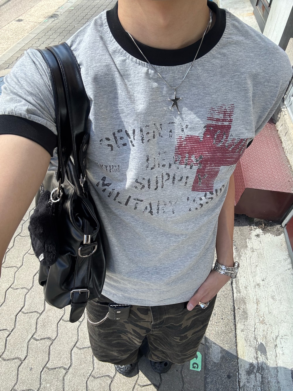 グレー系のTシャツ/カットソー、ブラック系のショルダーバッグ、その他のデニムパンツを着用したメンズの春コーディネートの5枚目の写真