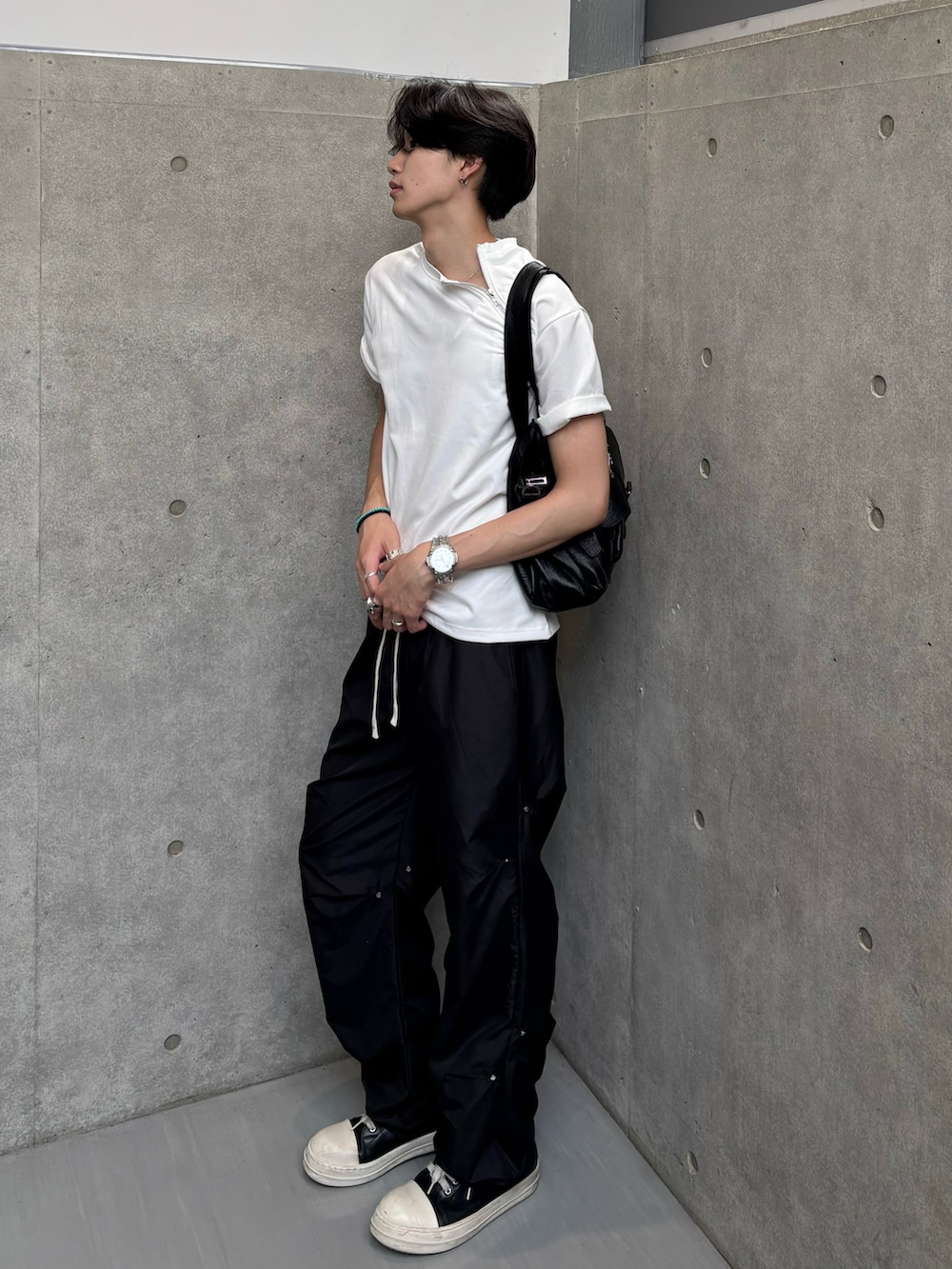ホワイト系のTシャツ/カットソー、ブラウン系のショルダーバッグ、ブラック系のパンツを着用したメンズの夏コーディネートの3枚目の写真