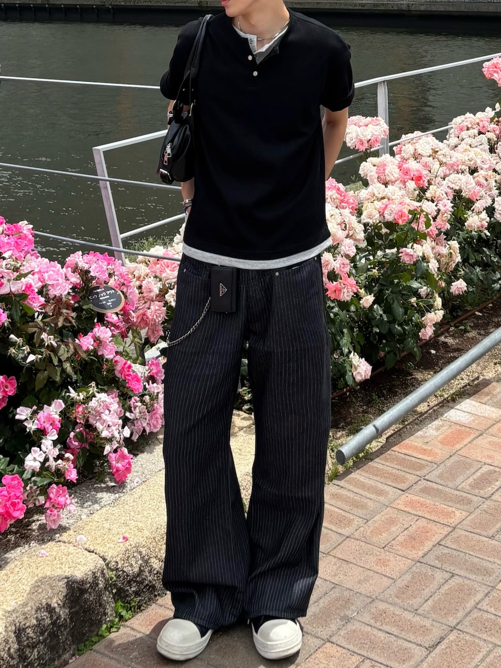 ブラック系のTシャツ/カットソー、ブルー系のデニムパンツ、ブラック系のスニーカーを着用したメンズの夏コーディネートの4枚目の写真
