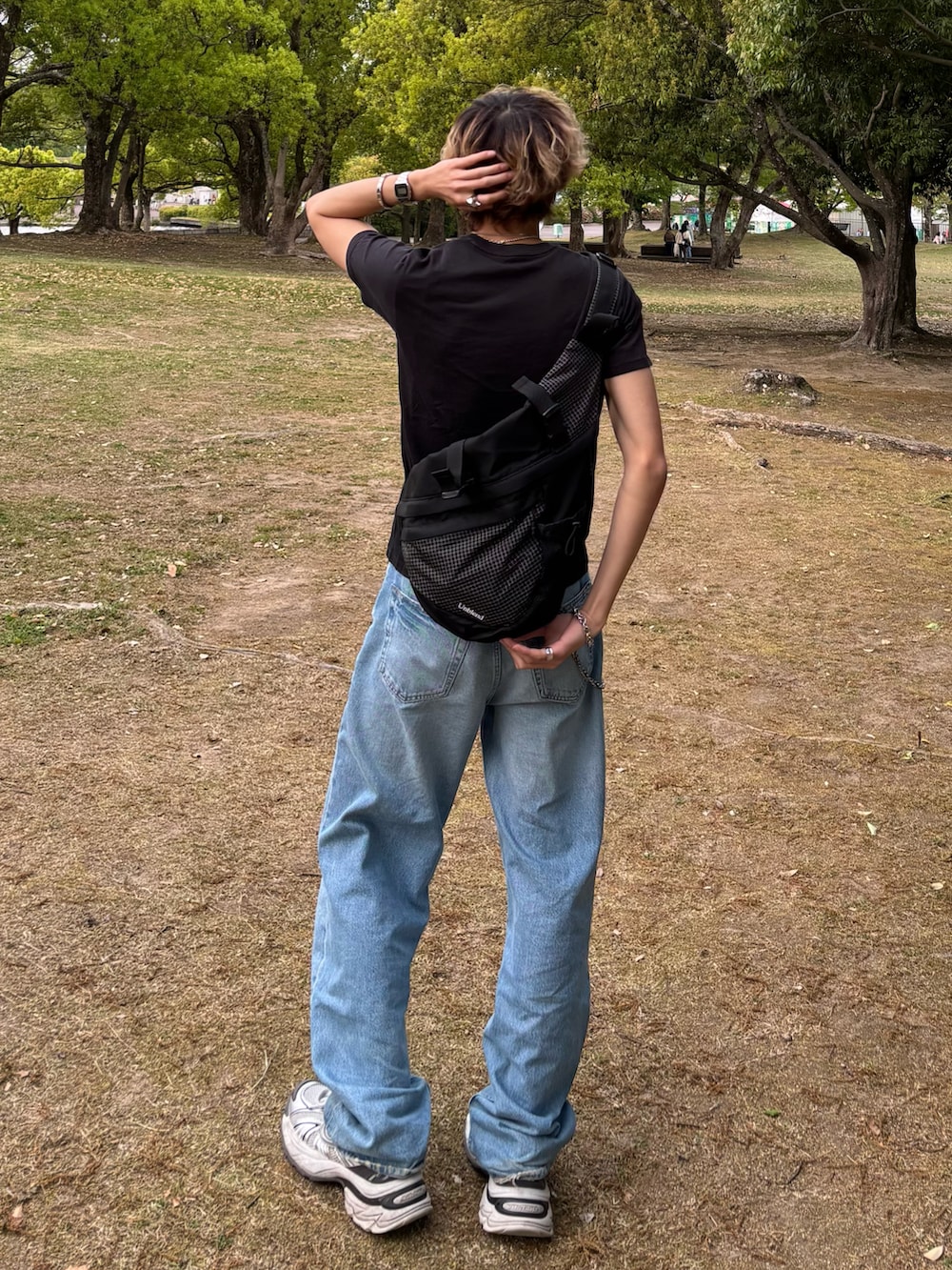 ブラック系のTシャツ/カットソー、ブルー系のデニムパンツ、ホワイト系のスニーカーを着用したメンズの夏コーディネートの2枚目の写真