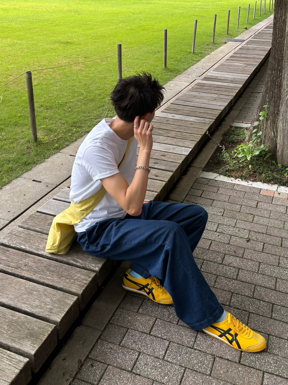 ホワイト系のTシャツ/カットソー、ブルー系のデニムパンツ、イエロー系のスニーカーを着用したメンズの夏コーディネートの3枚目の写真