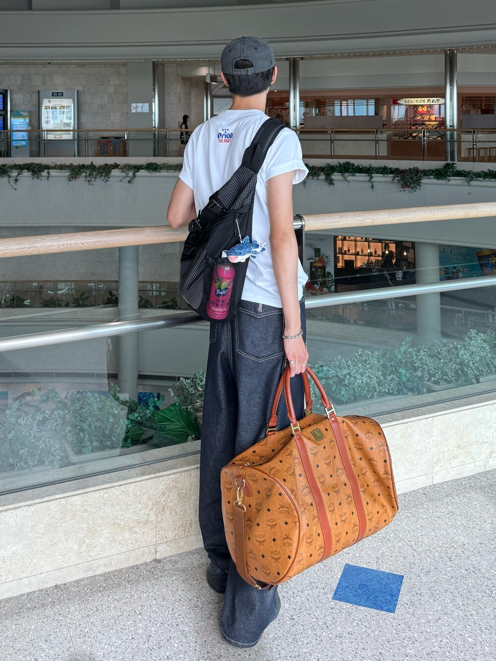 ホワイト系のTシャツ/カットソー、ブルー系のデニムパンツ、ブラック系のサンダルを着用したメンズの夏コーディネートの3枚目の写真