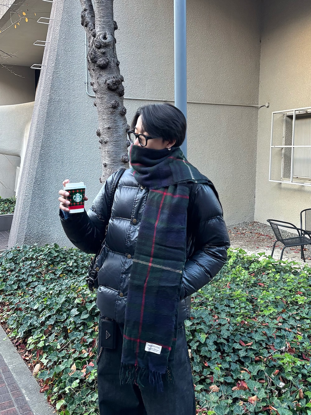 ブルー系のニット/セーター、ブラック系のデニムパンツ、ブラック系のスニーカーを着用したメンズの冬コーディネートの3枚目の写真