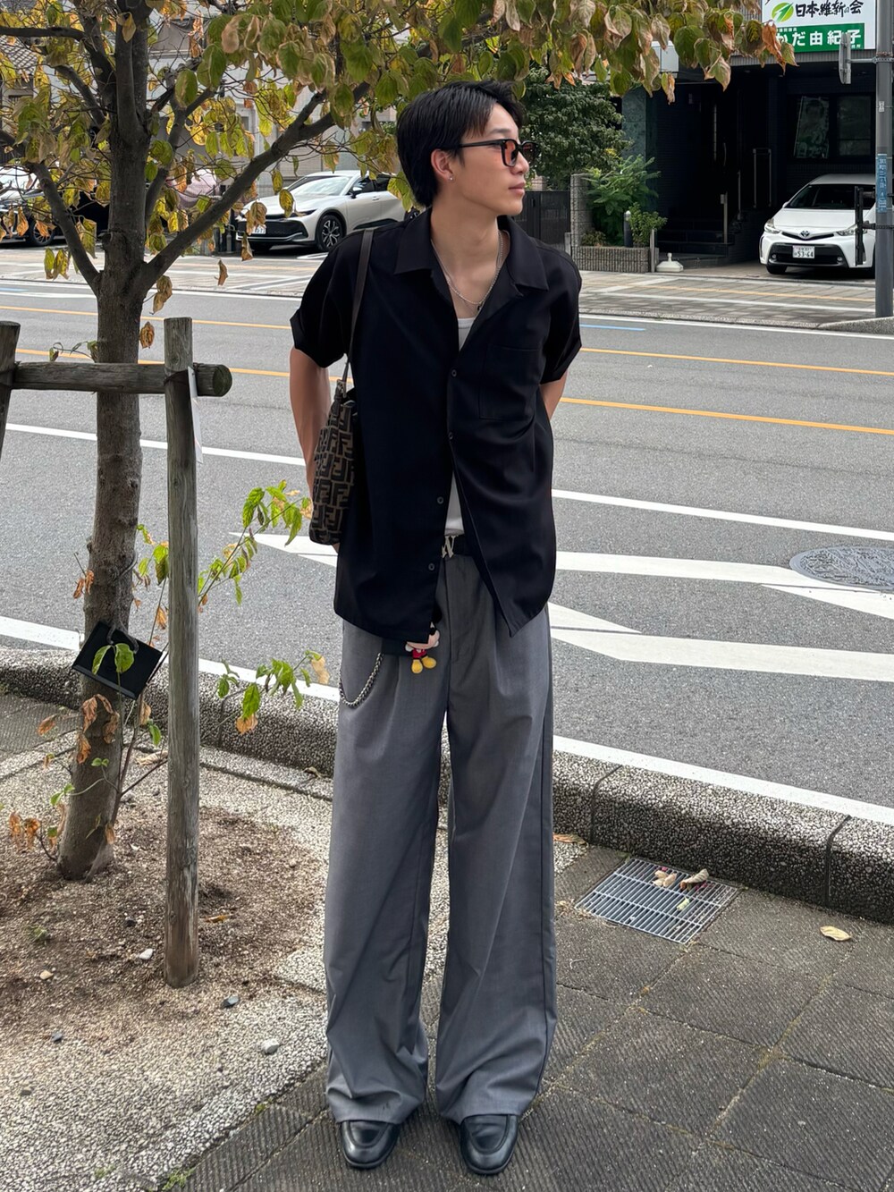 ブラック系のシャツ/ブラウス、グレー系のその他パンツ、ブラック系のローファーを着用したメンズの夏コーディネートの3枚目の写真