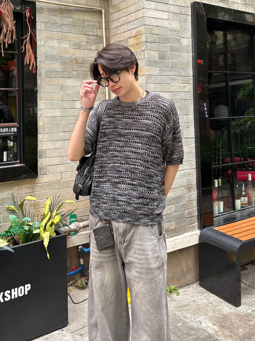 ブラック系のTシャツ/カットソー、グレー系のデニムパンツ、ブラック系のサンダルを着用したメンズの春コーディネートの4枚目の写真