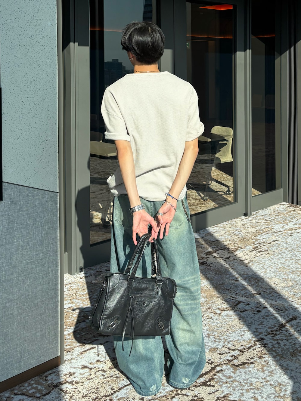 ベージュ系のTシャツ/カットソー、ブルー系のデニムパンツ、ブラック系のショルダーバッグを着用したメンズの春コーディネートの4枚目の写真