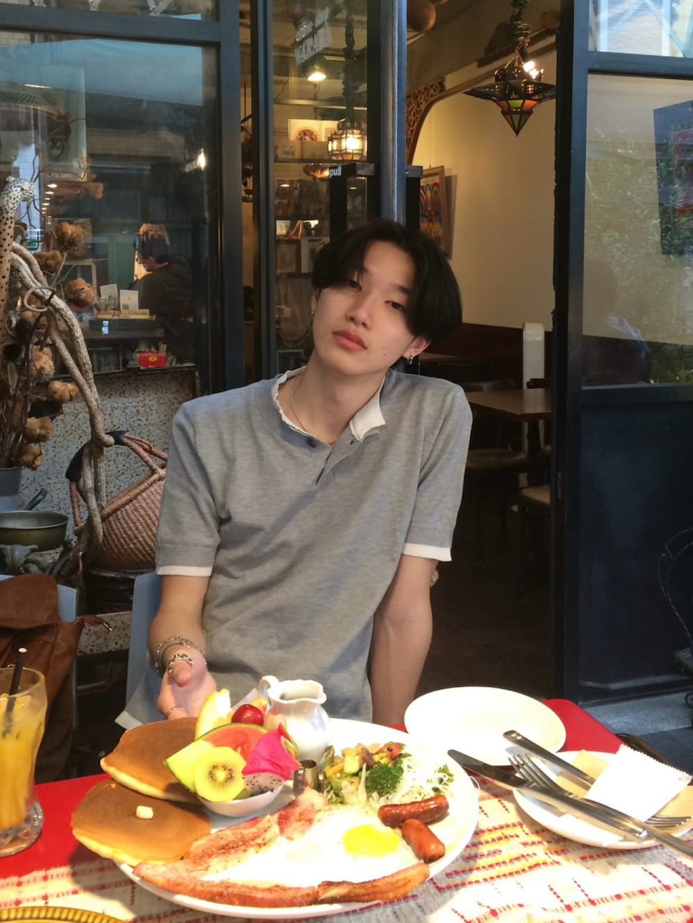 グレー系のTシャツ/カットソー、ブラック系のデニムパンツ、ブラック系のスニーカーを着用したメンズの夏コーディネートの3枚目の写真