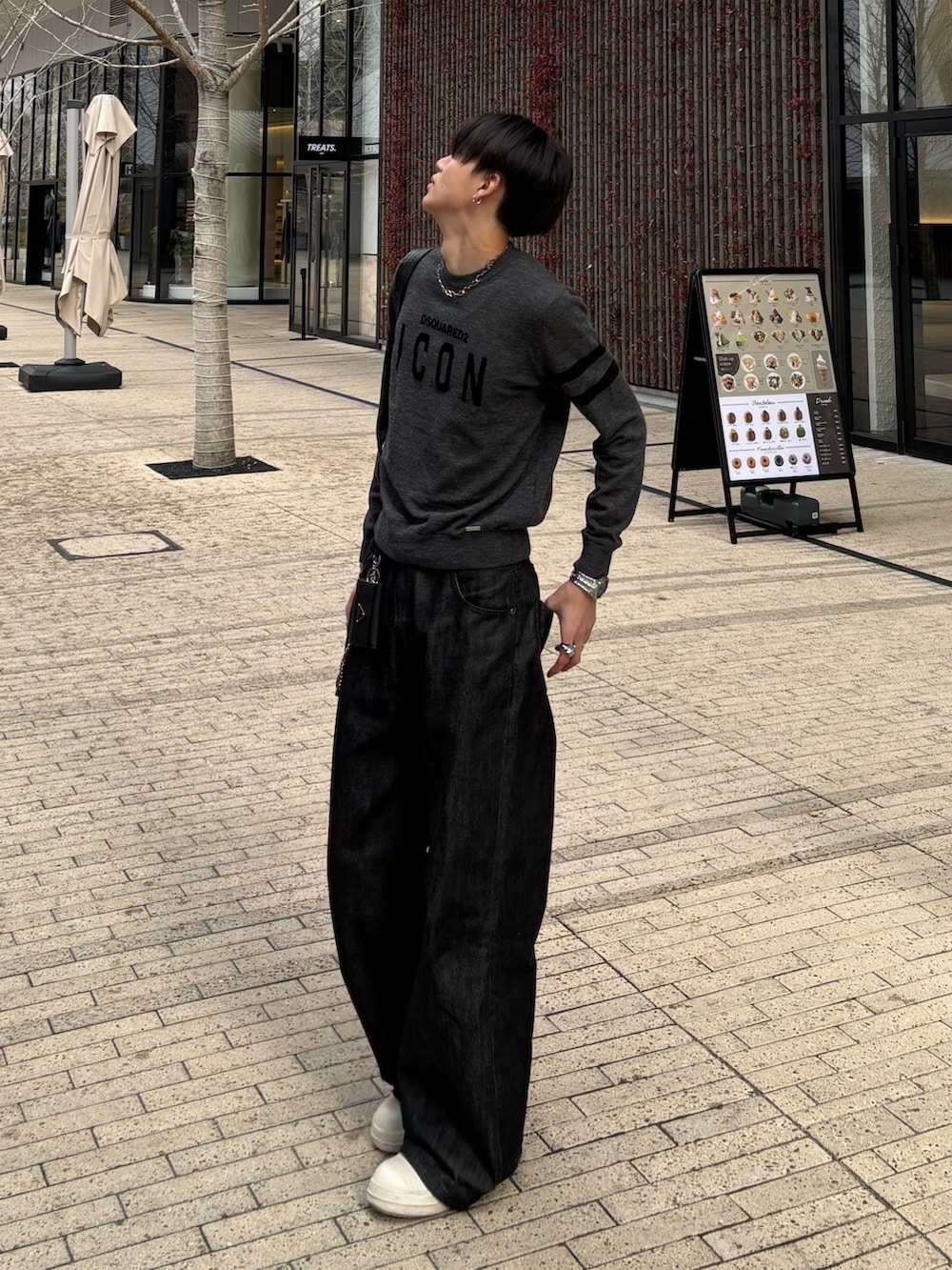 グレー系のニット/セーター、ブラック系のデニムパンツ、ブラック系のスニーカーを着用したメンズの冬コーディネートの2枚目の写真