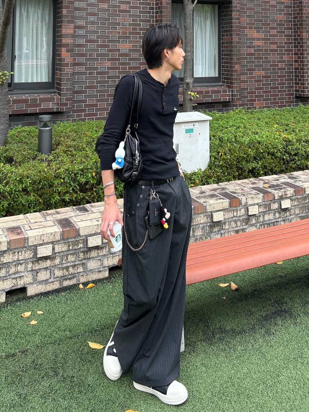 ブラック系のトップス、グレー系のスラックス、ブラック系のスニーカーを着用したメンズの秋コーディネートの2枚目の写真