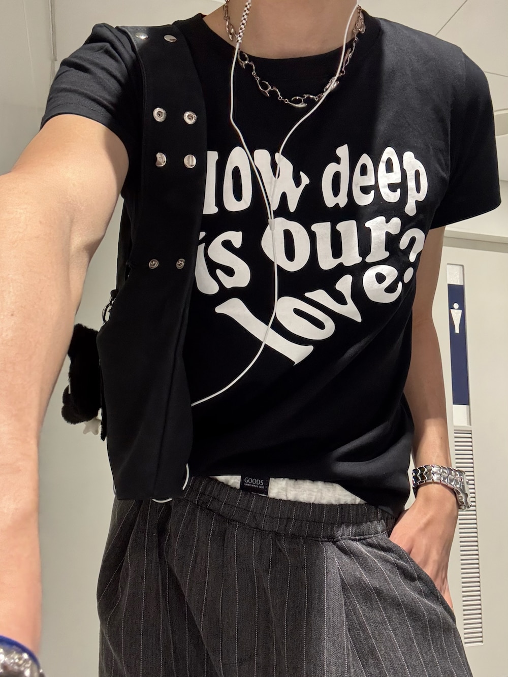 ブラック系のTシャツ/カットソー、ブラック系のショルダーバッグ、グレー系のスラックスを着用したメンズの春コーディネートの3枚目の写真