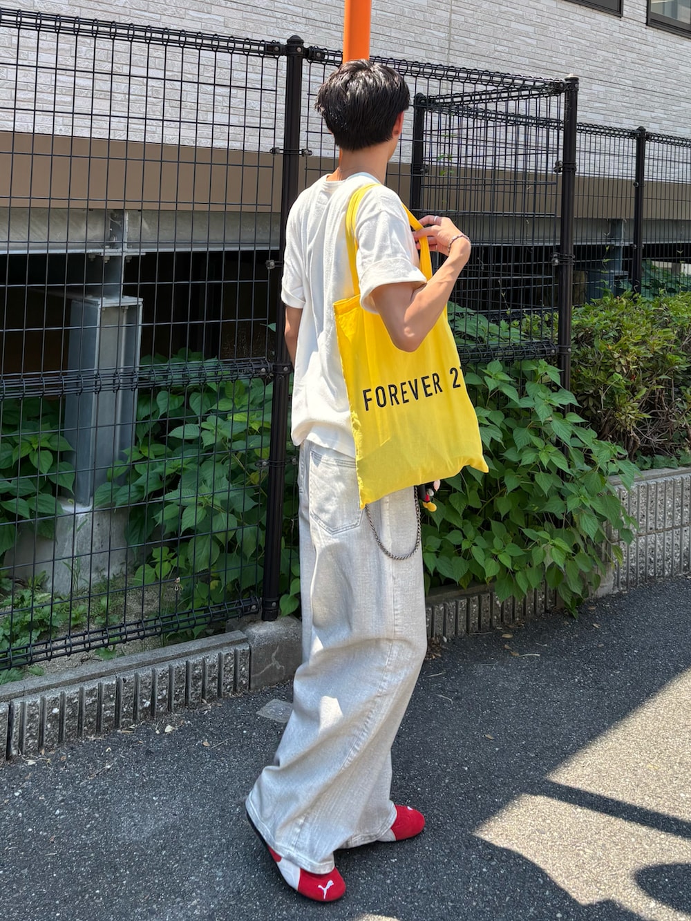 ホワイト系のTシャツ/カットソー、ホワイト系のデニムパンツ、レッド系のスニーカーを着用したメンズの夏コーディネートの2枚目の写真
