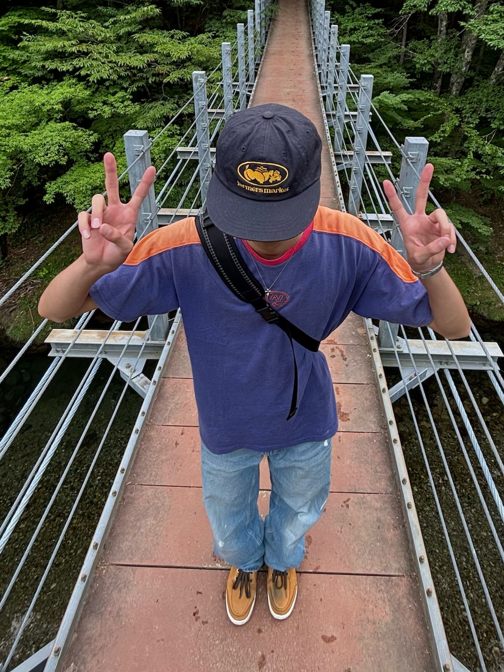 ブルー系のTシャツ/カットソー、ブルー系のデニムパンツ、ベージュ系のスニーカーを着用したメンズの夏コーディネートの3枚目の写真