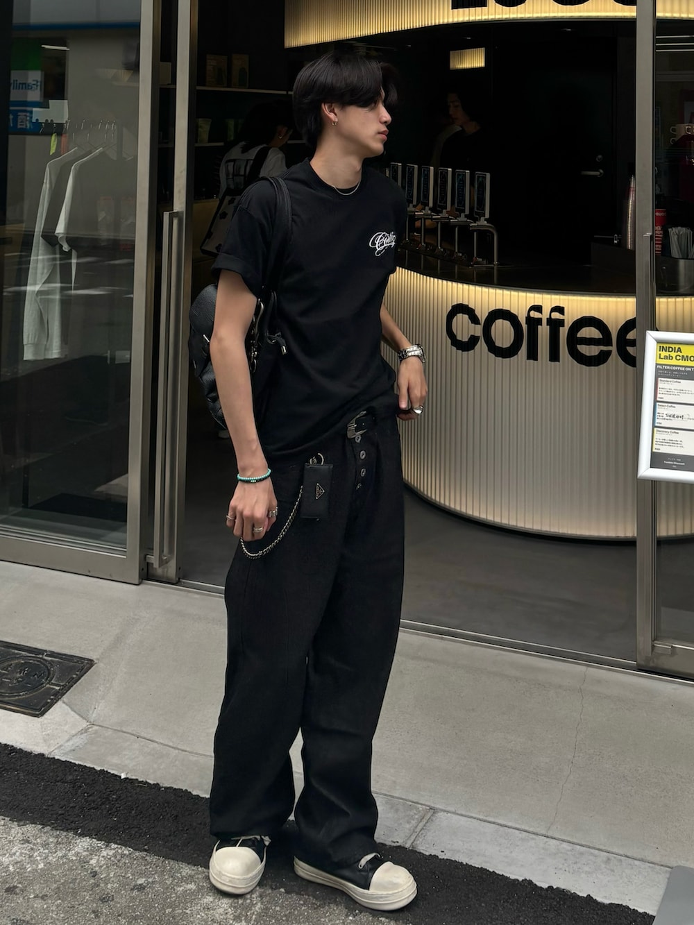 ブラウン系のショルダーバッグ、ブラック系のTシャツ/カットソー、ブラック系のデニムパンツを着用したメンズの夏コーディネートの2枚目の写真
