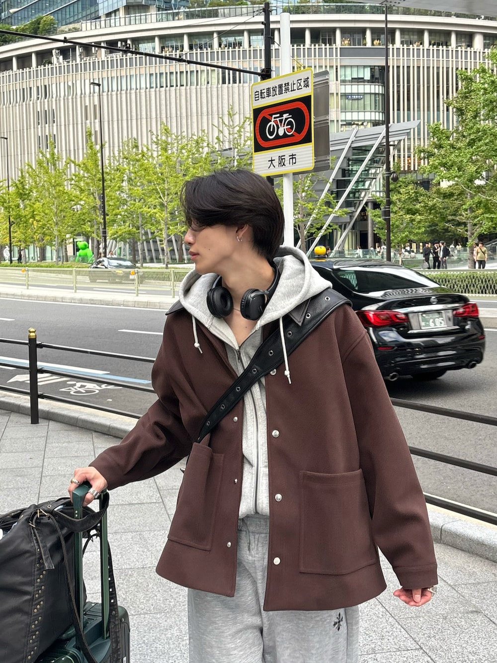 ブラウン系のステンカラーコート、グレー系のスウェットパンツ、ブラック系のスニーカーを着用したメンズの秋コーディネートの4枚目の写真