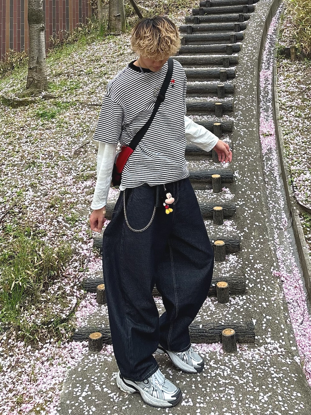 ホワイト系のTシャツ/カットソー、ブルー系のデニムパンツ、シルバー系のスニーカーを着用したメンズの春コーディネートの2枚目の写真