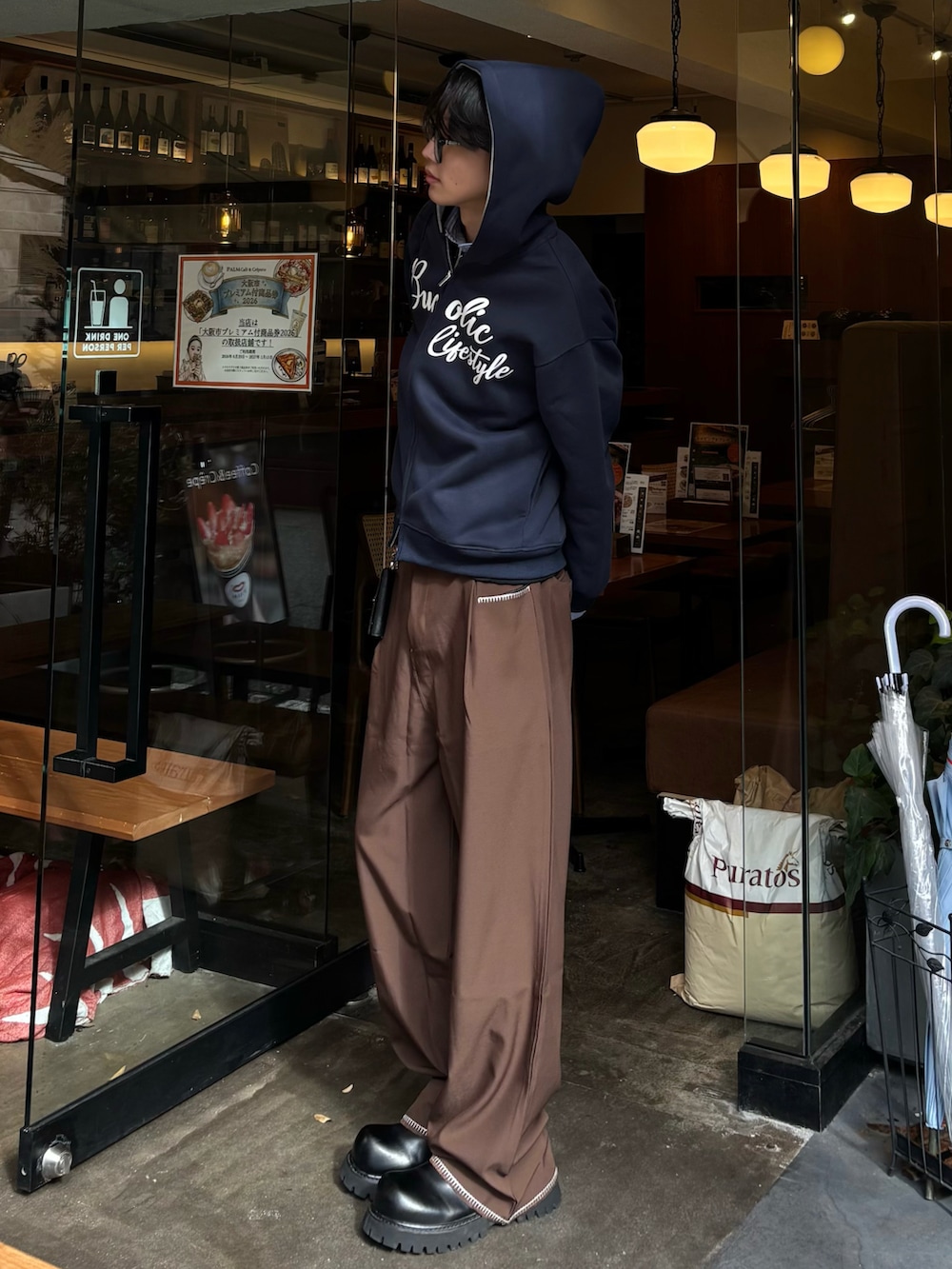 ブルー系のパーカー、ブラック系のスウェット、ブラウン系のスラックスを着用したメンズの秋コーディネートの3枚目の写真