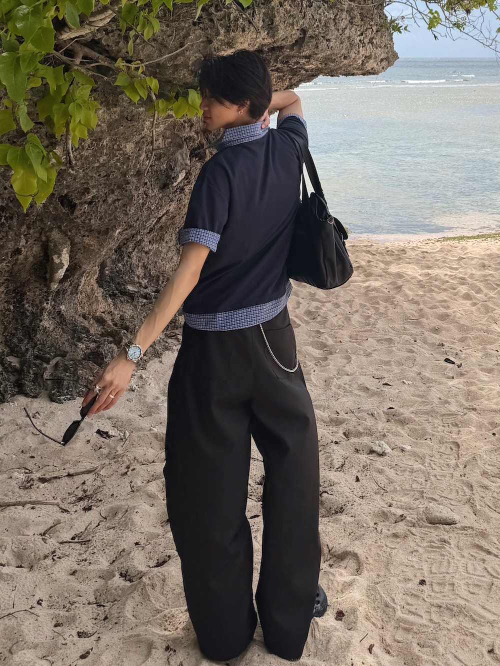ブルー系のTシャツ/カットソー、ブラック系のスラックス、ブラック系のサンダルを着用したメンズの夏コーディネートの3枚目の写真