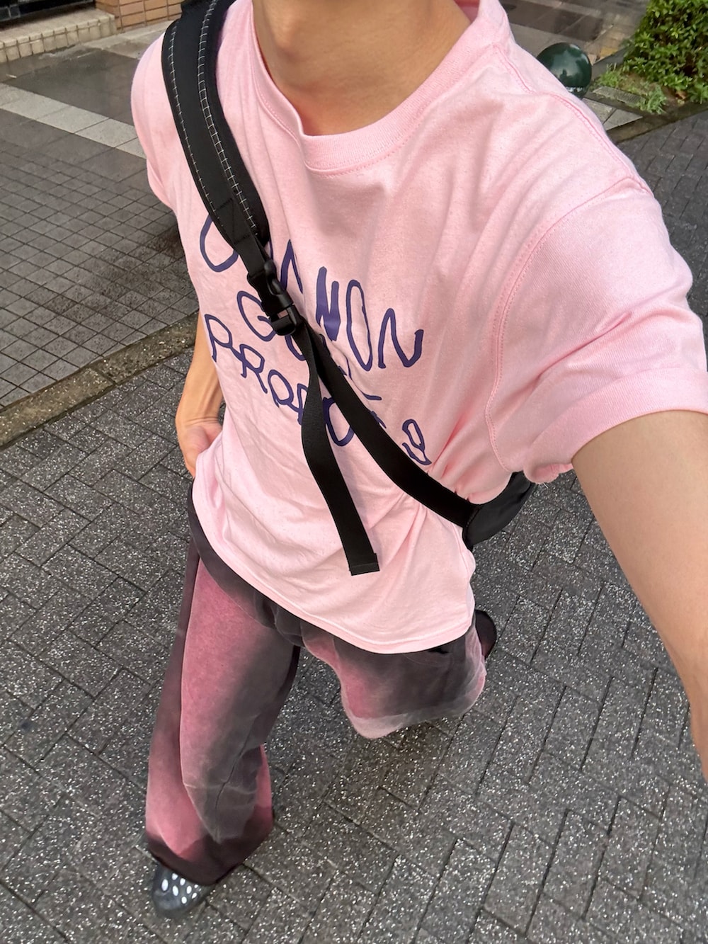 ピンク系のTシャツ/カットソー、ブラック系のスウェットパンツ、ブラック系のサンダルを着用したメンズの夏コーディネートの2枚目の写真