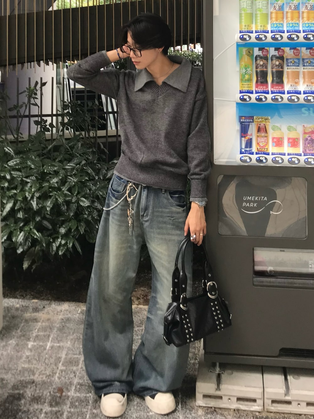 ブルー系のデニムパンツ、ブラック系のスニーカー、グレー系のニット/セーターを着用したメンズの秋コーディネートの3枚目の写真