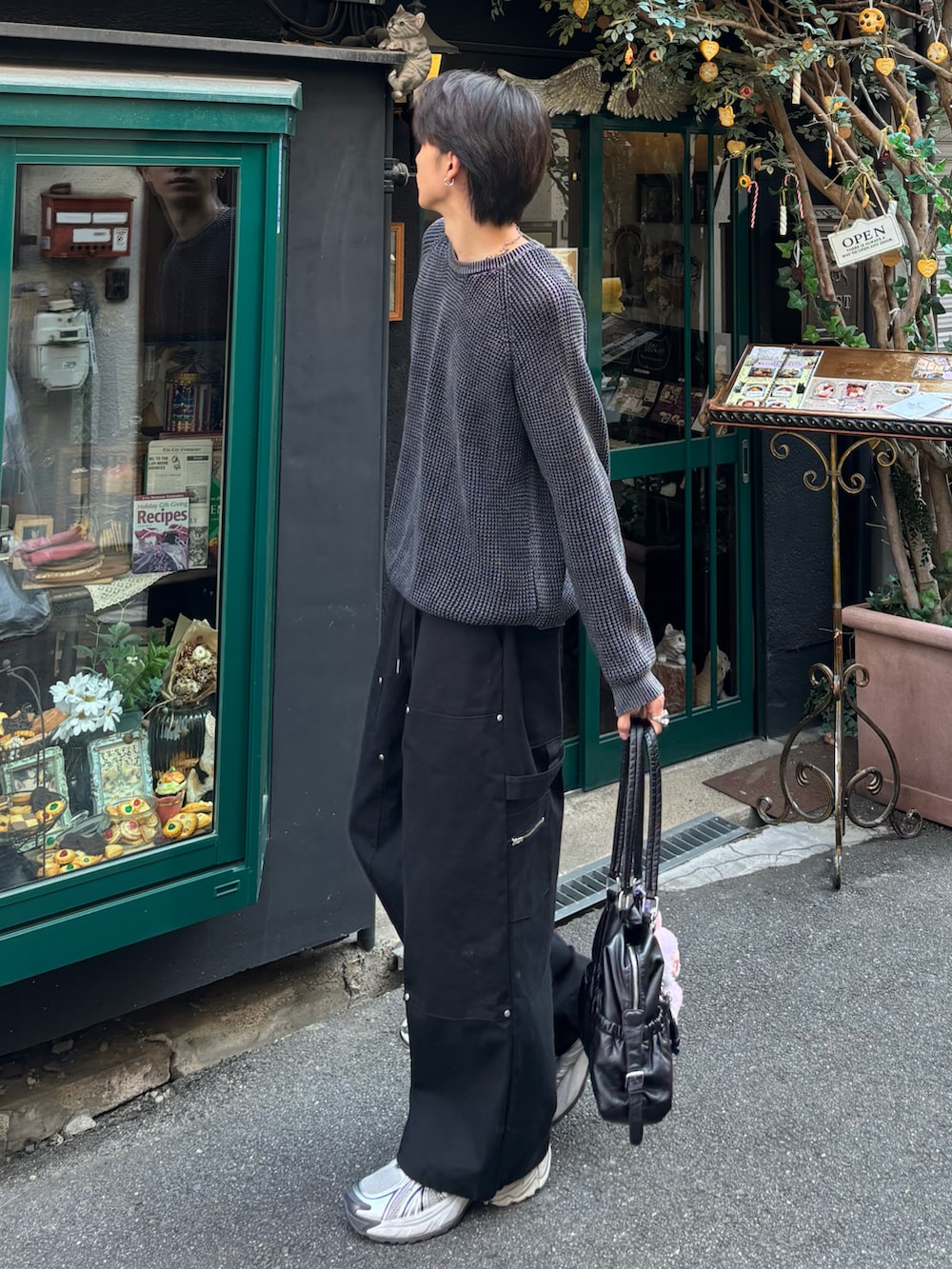 ブラック系のカーゴパンツ、ブラック系のニット/セーター、ホワイト系のスニーカーを着用したメンズの秋コーディネートの2枚目の写真