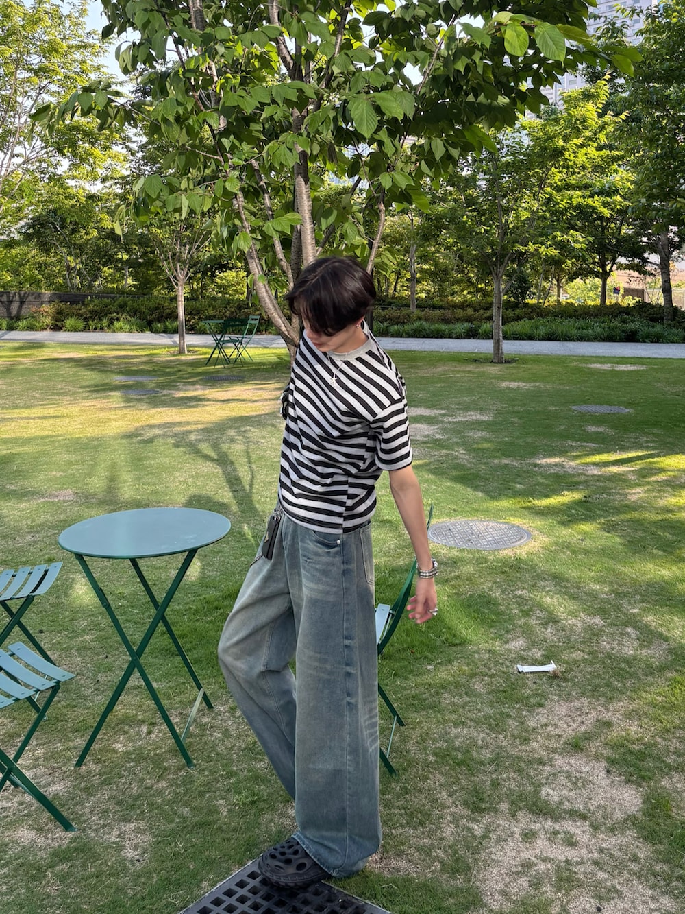 グレー系のTシャツ/カットソー、ブルー系のデニムパンツ、ブラック系のサンダルを着用したメンズの春コーディネートの3枚目の写真