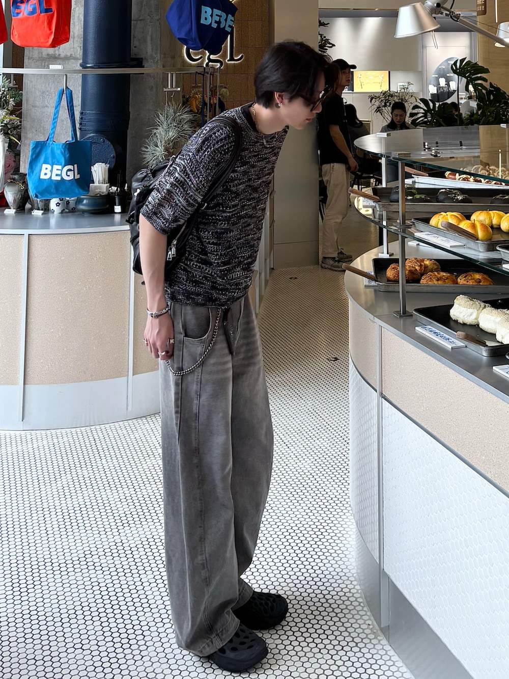 ブラック系のTシャツ/カットソー、グレー系のデニムパンツ、ブラック系のサンダルを着用したメンズの春コーディネートの3枚目の写真
