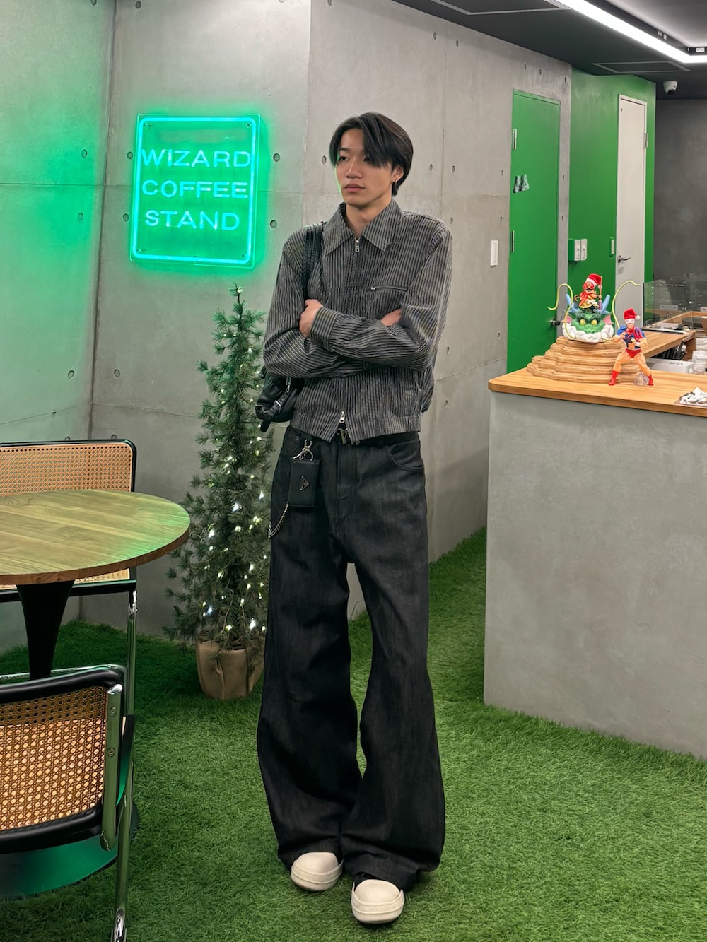 グレー系のブルゾン、ブラック系のデニムパンツ、ブラック系のスニーカーを着用したメンズの冬コーディネートの2枚目の写真