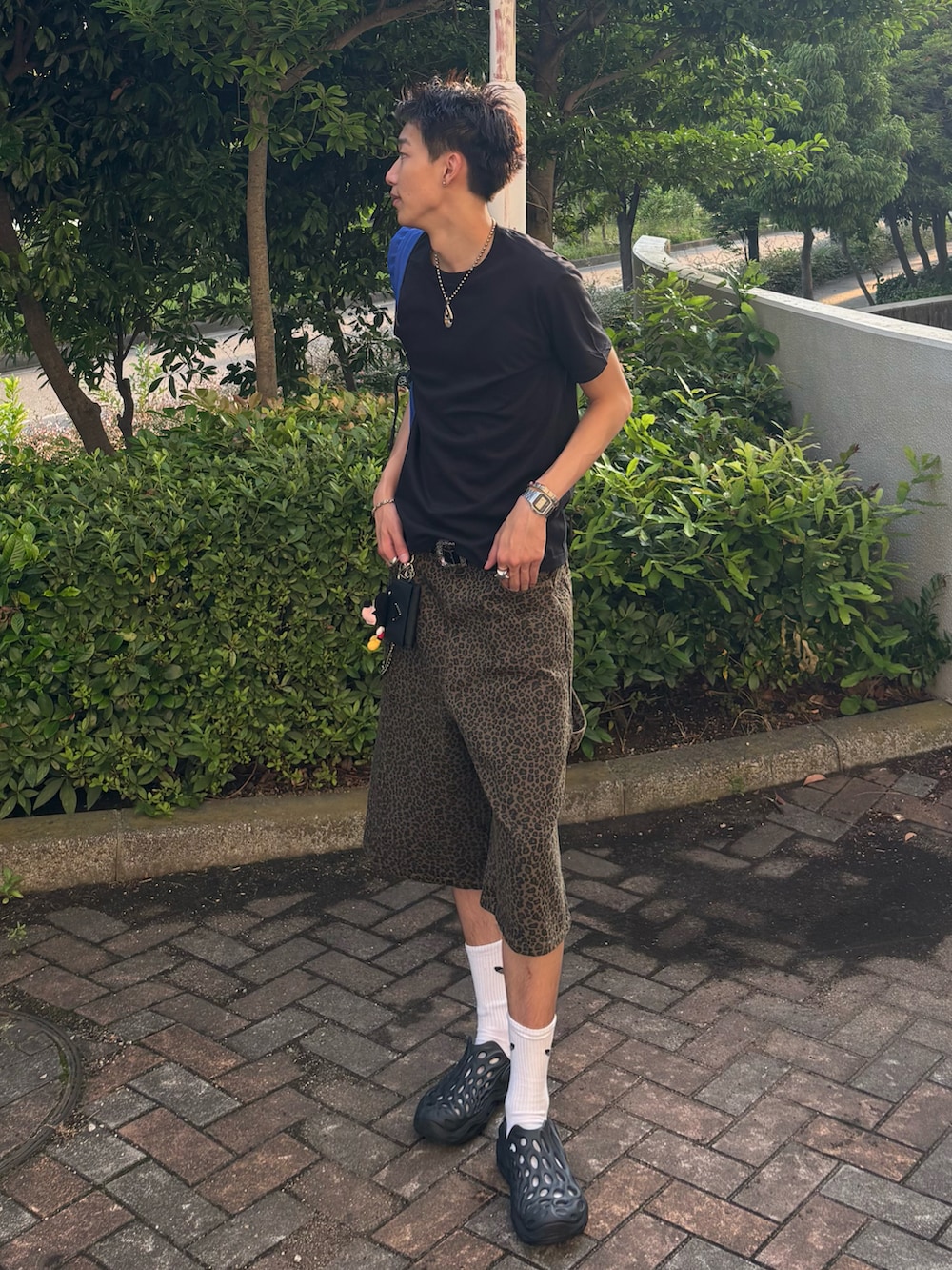 ブラック系のTシャツ/カットソー、ブラウン系のデニムパンツ、ブラック系のサンダルを着用したメンズの夏コーディネートの3枚目の写真