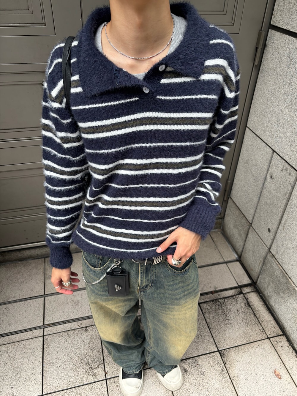 ブルー系のニット/セーター、ブルー系のデニムパンツ、ブラック系のスニーカーを着用したメンズの秋コーディネートの5枚目の写真