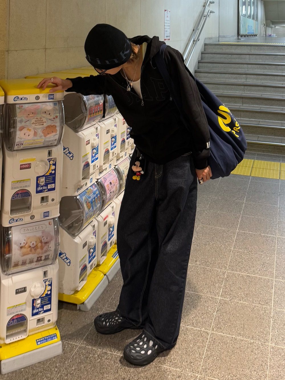 ブルー系のトートバッグ、ブラック系のパーカー、ブルー系のデニムパンツを着用したメンズの春コーディネートの2枚目の写真