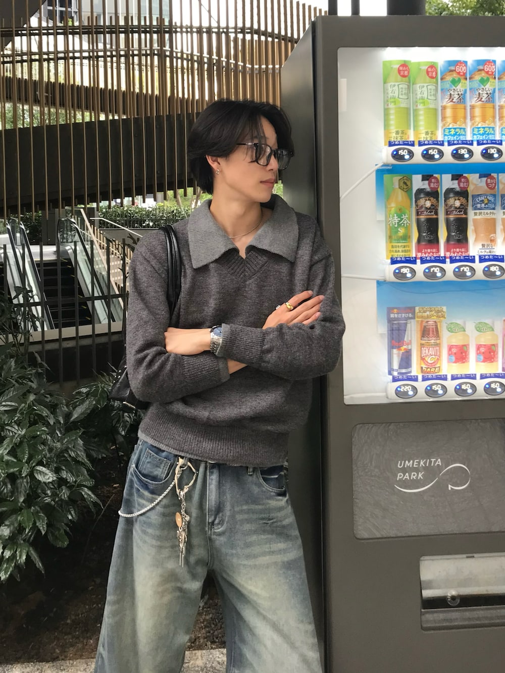 ブルー系のデニムパンツ、ブラック系のスニーカー、グレー系のニット/セーターを着用したメンズの秋コーディネートの5枚目の写真