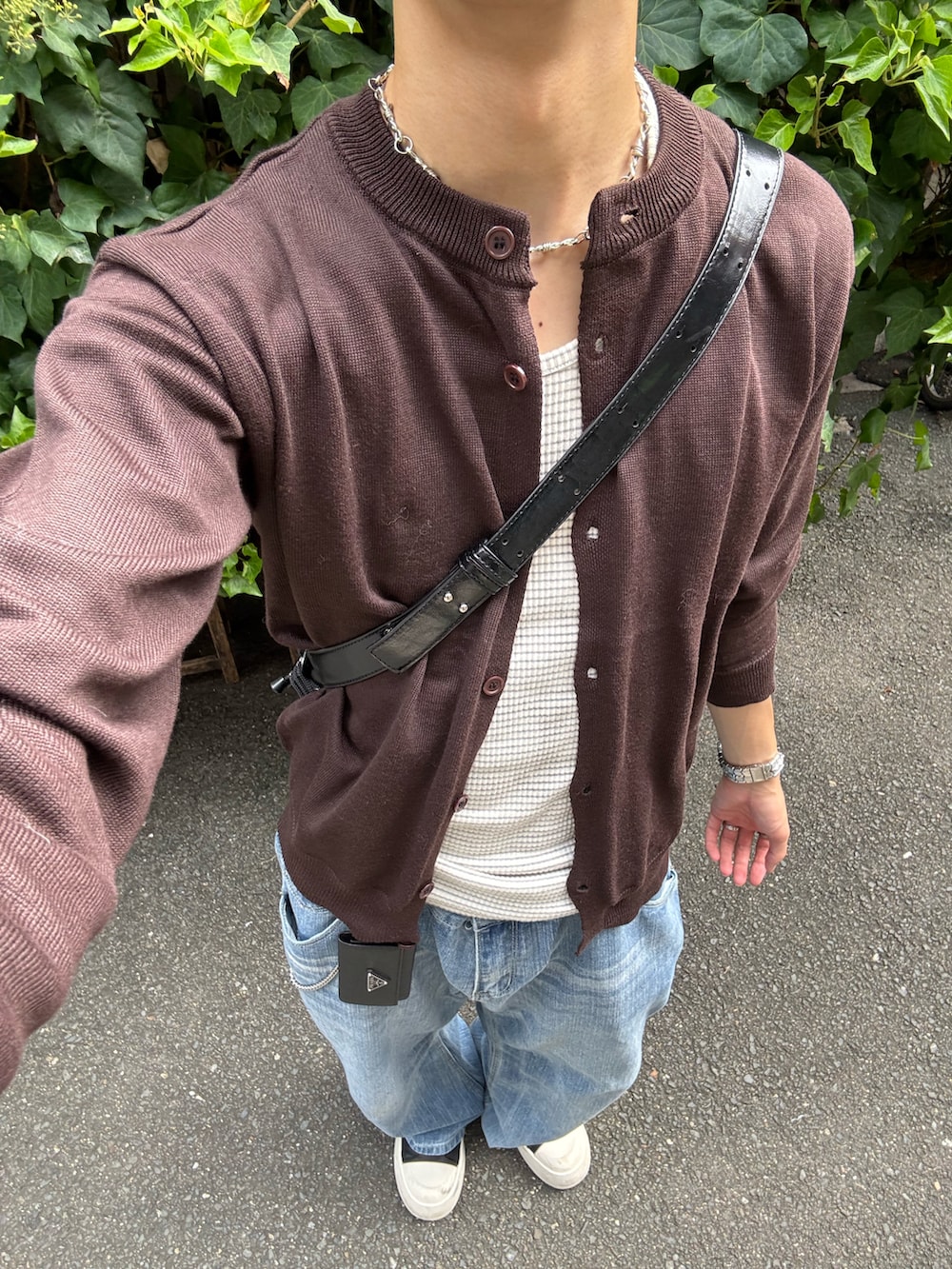 グレー系のタンクトップ、ブラウン系のカーディガン/ボレロ、ブルー系のデニムパンツを着用したメンズの秋コーディネートの5枚目の写真